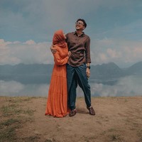 Kebahagiaan Laudya Cynthia Bella dan Engku Emran terlihat di foto kali ini. Engku Emran merangkul mesra Bella saat berdiri di atas bukit dengan pemandangan langit berawan saat foto prewedding outdoor.  Foto: Dok. Instagram @alvasus