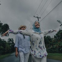 Keceriaan Laudya Cynthia Bella terlihat di foto prewedding outdoor ini. Ia tertawa bahagia sambil merentangkan tangannya ketika berjalan membelakangi Engku Emran. Konsep baju putih-biru muda membuat penampilan mereka terlihat serasi. Foto: Dok. Instagram @alvasus