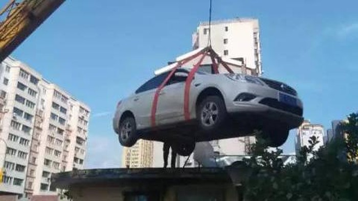 Parkir Sembarangan, Mobil Ini Dipindahkan ke Atap Rumah