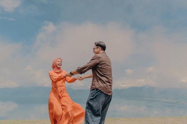 Ada pula sesi foto prewedding outdoor ala Laudya Cynthia Bella dan Engku Emran dengan latar belakang langit yang indah. Bella tampil feminin mengenakan gaun panjang dengan rok flare yang ringan. Foto: Dok. Instagram @alvasus