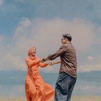 Ada pula sesi foto prewedding outdoor ala Laudya Cynthia Bella dan Engku Emran dengan latar belakang langit yang indah. Bella tampil feminin mengenakan gaun panjang dengan rok flare yang ringan. Foto: Dok. Instagram @alvasus