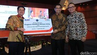 Menteri Ketenagakerjaan Hanif Dhakiri (kanan) menyaksikan Direktur Bisnis Kecil dan Jaringan BNI Catur Budi Harto (tengah) memberikan mock up kepada Sekjen Pembinaan Pengawasan Ketenagakerjaan Hery Sudarmanto di Jakarta, Senin (11/09/2017) malam. 