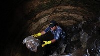 Ada kalanya grave cleaner masuk ke dalam kuburan masal bukan untuk meletakkan mumi atau sisa tengkorak. Tapi justru mencari tengkorak yang kuburannya sudah di bersihkan karena ada keluarga yang mencari (Jorge Dan Lopez/Reuters)