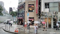 Banyak orang melewati Ginza sambil membawa payung.