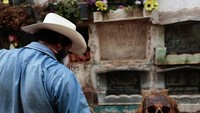Ada jenazah yang masih berbentuk. Ada pula yang sudah hancur dan hanya menyisakan beberapa tulang. Grave cleaner haruslah memasukkan tengkorak-tengkorak tersebut ke dalam plastik (Jorge Dan Lopez/Reuters)