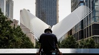 Petugas NYPD (New York Police Department) mengheningkan cipta di tepi kolam di National 9/11 Memorial and Museum. (REUTERS/Brendan McDermid)