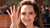 Angelina Jolie tampil dengan gaun putih saat hadir dalam festival tersebut. Foto: Alberto E. Rodriguez/Getty Images