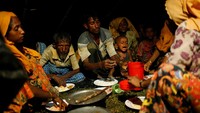 Mereka makan malam dengan pencahayaan seadanya. Foto: REUTERS/Mohammad Ponir Hossain
