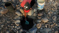 Warga mengambil air dari mata air sumur buatan, di bantaran Sungai Cipamingkis, Cibarusah, Kabupaten Bekasi, Jawa Barat, Kamis (7/9). (Foto: ANTARA FOTO/Risky Andrianto)