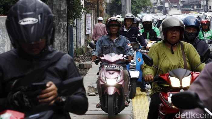 Pengendara sepeda motor menerobos trotoar di Jalan Jatinegara, Jakarta, Selasa (13/9/2017). Mereka nekat melintas di jalur pejalan kaki untuk menghindari macet dan bekas galian.