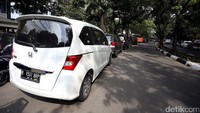 Sejumlah mobil diparkir berjajar di bahu Jalan Raden Fatah.