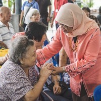 Busana berpalet hangat juga jadi pilihannya saat mengunjungi para penghuni Marsiling, kompleks apartemen di wilayah suburban yang banyak dihuni penduduk lansia. Halimah Yacob tampak mengenakan baju kurung warna peach dengan hiasan bordir.  Foto: Instagram