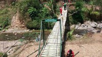 Batalyon Infanteri Raider 303/SSM Kostrad bekerjasama dengan Vertical Rescue Indonesia membangun jembatan gantung di Desa Cihike. (Penkostrad).
