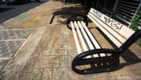Corat-coretan itu merusak keindahan fisik bangku pedestrian.