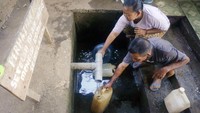 Warga mengambil air bersih menggunakan jerigen dan botol di sumber air bersih Desa Tanjungsari, Tulungagung, Jawa Timur, Jumat (8/9). Kekeringan yang mulai melanda sebagian desa di daerah itu menyebabkan warga mencari bahan baku untuk air minum di sumber air yang masih aktif, meski jaraknya jauh.  (Foto: ANTARA FOTO/Destyan Sujarwoko)