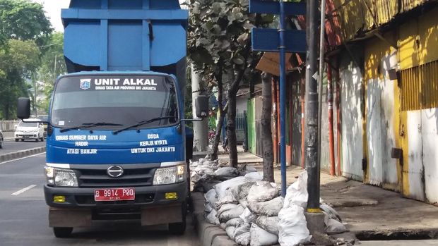 Lumpur-lumpur di selokan ini dikeruk untuk meminimalisir genangan.