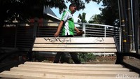 Seorang warga melintas di belakang bangku yang dikotori coretan.
