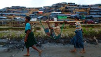 Dua anak memikul seorang nenek di pengungsian, Rabu (13/9/2017). Foto: REUTERS/Danish Siddiqui