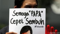 Seorang aktivis memamerkan poster bertuliskan Semoga Papa Cepet Sembuh.