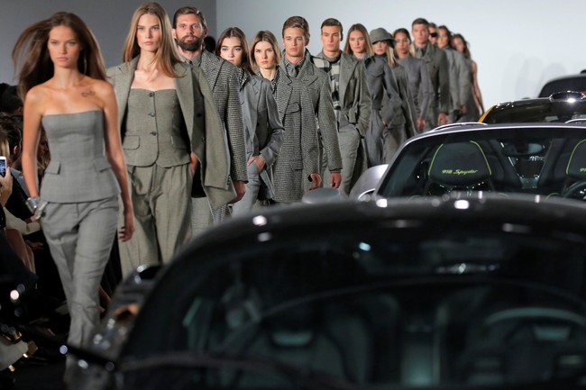 Mobil-mobil tersebut diparkir berbaris di tengah catwalk. Para model lalu berlenggang mengitarinya. Foto: Reuters