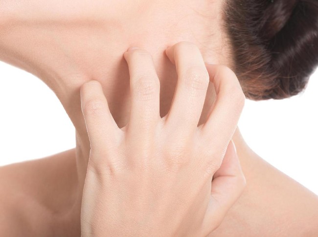 Young beautiful topless woman is scratching her neck. Isolated on white.