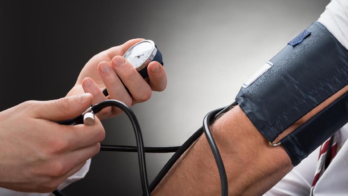 Close-up Of A Doctors Hand Checking Blood Pressure Of A Patient