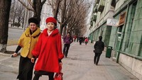 Seorang warga berjalan mengenakan busana khas Pyongyang yang dipengaruhi oleh Ri Sol-Ju, istri Kim Jong-Un. Instagram/@shaneohodhrain  