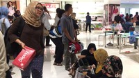 Saking panjangnya, beberapa pengunjung harus antre dengan duduk-duduk di lantai.