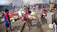 Warga mengevakuasi barang yang bisa diselamatkan.