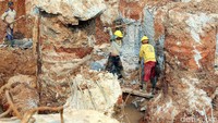 Pekerja melakukan penggalian di lokasi pembangunan.
