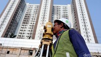 Pekerja melakukan pengukuran tanah di lokasi proyek pembangunan apartemen Grand Dhika City Lifestyle di Jati Warna, Kota Bekasi.