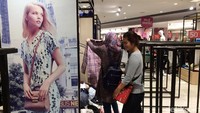 Dua orang pengunjung memilih pakaian yang didiskon.