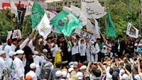 Massa membawa atribut aksi seperti bendera.