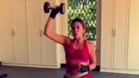 Tak lupa ia melatih otot tangannya menggunakan barbell. Wanita 33 tahun ini menggerakan tangan kesamping dan ke atas. (Foto: instagram/khloekardashian)