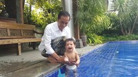 Setelah asyik bermain, sekarang saatnya mandi! Seru banget ya Jan Ethes dimandikan kakeknya (Foto: Screenshot Vlog Jokowi)