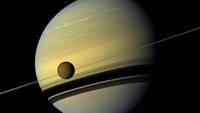 Titan, satelit terbesar Saturnus, tertangkap kamera berada di depan planet ini saat sedang mengalami perubahan musim. Foto ini dirilis oleh NASA pada 29 Agustus 2012 (NASA/JPL-Caltech/Space Science Institute/Handout via REUTERS)