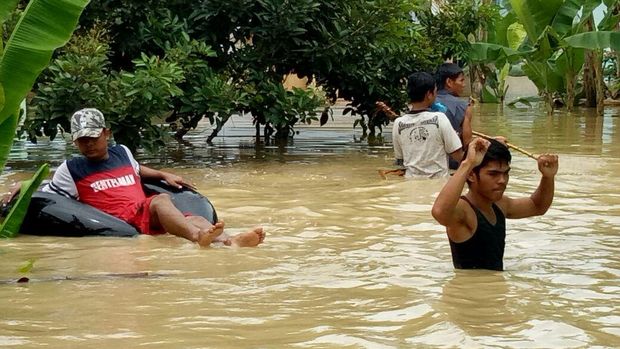 Masyarakat mengungsi ke rumah warga yang tidak terlanda banjir. Petugas gabungan juga bantu mengevakuasi warga.