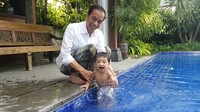 Saking girangnya, Jan Ethes tampak semangat bermain air sambil dipegangi Jokowi (Foto: Screenshot Vlog Jokowi)