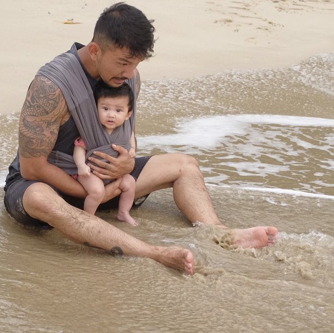 Penampilan Rio Dewanto dengan brewok, tato dan tubuhnya yang atletis saat menggendong bayinya inilah yang membuat netizen menjulukinya hot daddy. Foto: Dok. Instagram Rio Dewanto