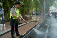 Kombes Iqbal saat ikut membersihkan jalan yang tergenang oli
