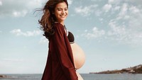 Acha Septriasa tampak seksi dengan outer berwarna merah tua. Ia terlihat tak mau ketinggalan untuk mengabadikan momen kehamilannya.  Instagram @achaportraits