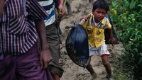 Seorang anak pengungsi Rohingya membawa barang-barangnya saat ia berjalan ke sebuah kamp darurat di Coxs Bazar, Bangladesh . REUTERS/Danish Siddiqui