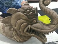bagian kepala artefak menyerupai bentuk naga dengan belalai gajah yang mengarah ke atas. 