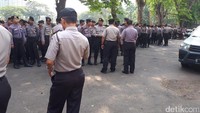 Polisi berjaga di sekitaran lokasi. Membentuk perimeter barisan.