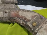 Sekilas artefak berwujud seperti kepala naga yang menggunakan mahkota di atasnya. Sementara bagian badan memanjang dengan aneka ornamen dan sisik di sejumlah sisinya.