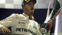 Hamilton mengangkat Piala. Foto: Getty Images