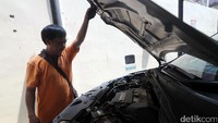 Warga melihat mesin mobil yang akan dilelang.