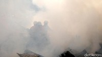 Asap mengepul menyelimuti petugas yang tengah bertugas.