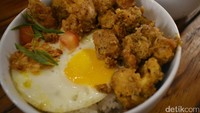 Rice bowl yang ada di Eatsomnia ini bisa Anda nikmati 24 jam. Nasi hangat ditambah dengan ayam berbalut tepung dan telur asin makin enak dimakan dengan telur ayam. Gurih dan bikin kenyang! Foto: Lusiana Mustinda