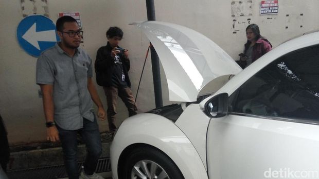 Mobil VW Beetle berwarna putih menarik perhatian pengunjung yang datang